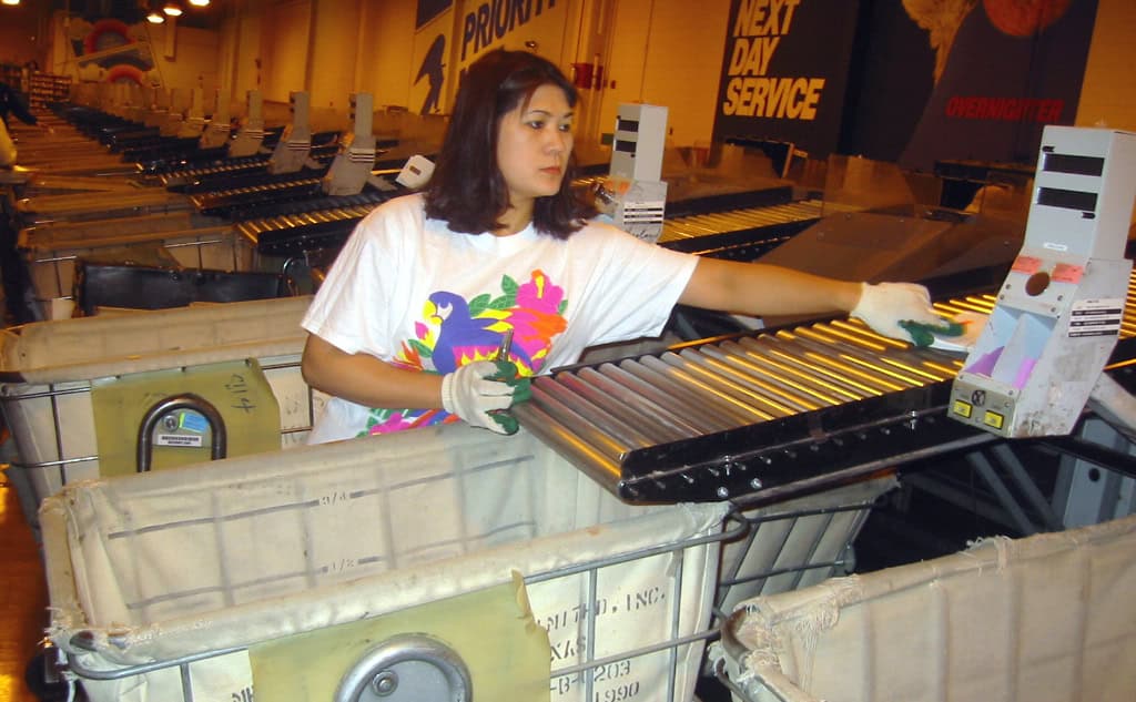 USPS - SPBS (Small Parcel Bundle Sorter) - worker loading mail into bin