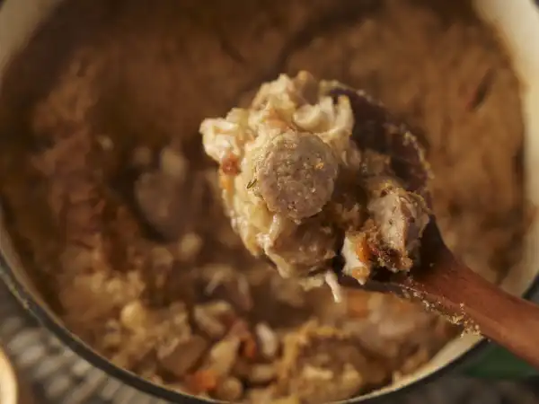 Sausage and Bean Stew 125 - Sausage & Bean Stew is a hearty and savory dish perfect for satisfying a robust appetite. This flavorful stew combines a medley of ingredients such as chicken thighs, sweet Italian sausage, and bacon, which are cooked to perfection and intertwined with the earthy textures of carrots, celery, and onion.