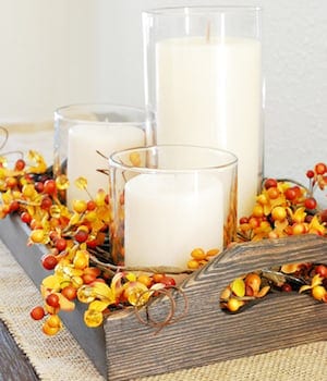 Wood tray and candles - Rustic fall decor embodies the cozy charm and natural beauty of the autumn season. Drawing inspiration from the rich hues of changing leaves, the crispness in the air, and the warmth of harvest gatherings, rustic fall decor incorporates elements such as weathered wood, burlap, dried foliage, and muted earth tones.