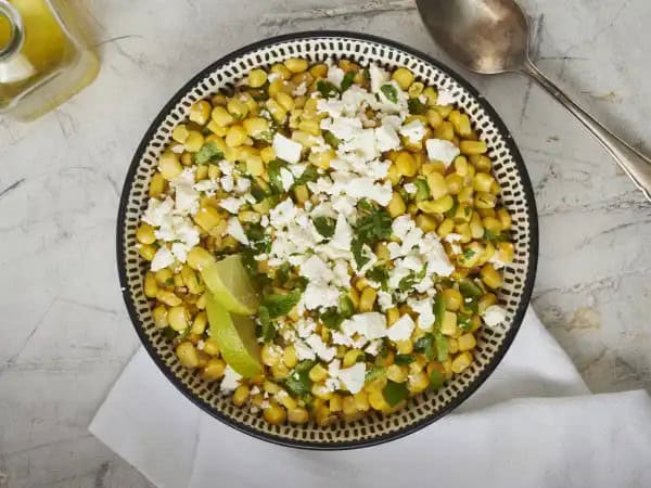 image 12291 - Add something fresh and flirty to your next meal! Corn Feta Salad will captivate your palate in a whole new way. Fresh-from-the-ear sweet corn is dressed to impress with some crumbled feta cheese, plus jalapeño to spice things up a bit, and a delightful rumba of flavor from your favorites like parsley, mint, flaky sea salt, and fresh lime juice. With a drizzling of olive oil, all the tastes of Corn Feta Salad join into an exciting new way to serve a side dish. Fresh has never been so attractive!