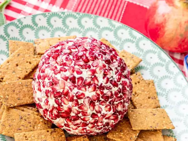 image 13102 - If you're feeling a little cheesy this holiday season, you're going to need more than just your tacky Christmas sweater to really live out your festive party dreams! But really... whether the theme is tacky or classy, everyone needs a Holiday Cheeseball at their brilliant winter bash! What would people even dip their crunchy, dry crackers into if there wasn't a beautifully rich, creamy, pomegranate seed-coated sphere of amazingness waiting for them on the snack table?! (This one really is beautifully festive, too, with all of those hints of red!) They'd be so lost without it. Luckily for them, you know what's up! We're positive you'll always want this Holiday Cheeseball at your Christmas party, whether it be a glamorous gala or a ridiculously fun hootenanny!