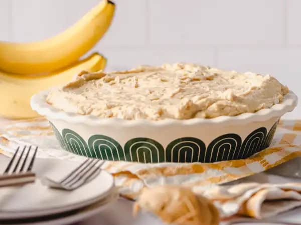 image 13605 - An American twist on an English favorite! Peanut Butter Banoffee Pie is a luxurious dessert that really highlights the fun of indulging your sweet tooth. A crumbly, buttery crust made from Chocolate Hobnobs® (a beloved English oat cookie) supports sweetened, caramelized bananas (which could be a dessert just by themselves) and some rich, creamy, and deeply flavorful dulce de leche. This combination of flavors would be fantastic all on its own... but then it gets even better with a gloriously fluffy peanut butter whipped cream topping. Doesn't the sound of that just make you feel happier? Peanut Butter Banoffee Pie brings a beloved dessert across the pond to a new and eager audience!
