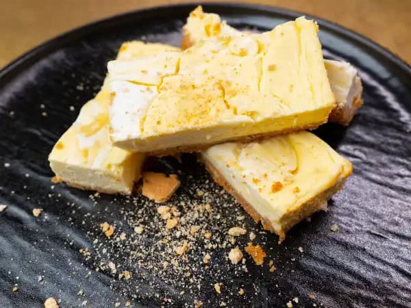 image 13710 - Lemon Swirl Cheesecake Bars just might be the sweetest treat you'll ever eat! These creamy, citrusy bites are loaded with lemon flavors that will have you daydreaming of the dreamiest summer day there ever was. And that sweet graham cracker crust complements the slightly tangy topping so well. Lemon Swirl Cheesecake Bars taste like a daydream that came true! So, enjoy every last crumb!