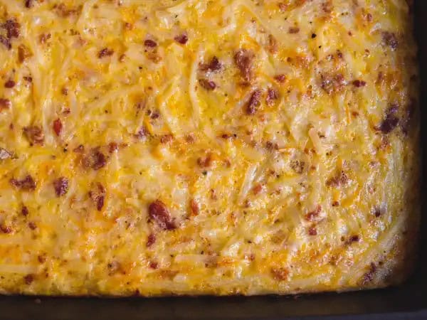 image 14030 - Food in the morning is a must. But cheese in the morning, that sure is a pleasure. Cheesy Amish Breakfast Casserole makes sure you're fed with everything you crave just as soon as you rise and shine. Fluffy eggs, crispy bacon, and crunchy hash brown potatoes? Yep, it's got all of that! And you can be purely delighted by all the creamy, melty, gooey cheese blended in. Cheesy Amish Breakfast Casserole has got it all and then some. Get ready to wake up to some cheesy greatness!