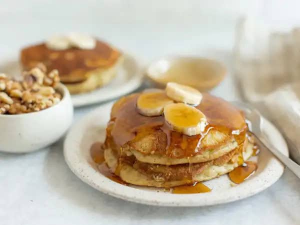 image 14189 - The rich, tropical, creamy flavor of banana is infused into each bite of the Best Banana Bread Pancakes; in fact, that's part of why they are the best! The fact that these fluffy treats are so light and sweet and packed with crunchy walnuts before being pan-fried in butter is the other (very good) reason! The Best Banana Bread Pancakes taste like the best of both worlds, and breakfast will never be the same!
