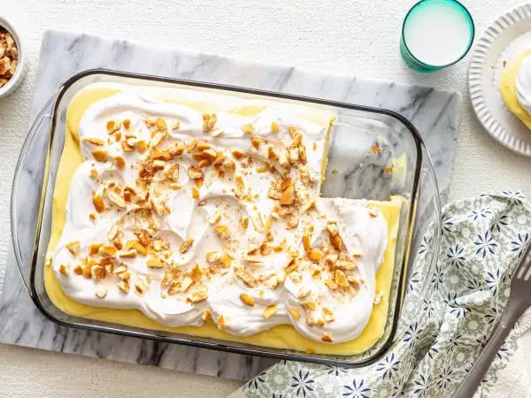 image 14330 - Want to know our favorite hack for hosting?! It's this Banana Pudding Poke Cake! What tastes like made-from-scratch, is actually our favorite moist and sweet boxed yellow cake. We poke a few holes in the top and cover it with creamy banana pudding, fluffy whipped topping, crunchy crushed vanilla wafers... all from a box or a tub, but you'd never know it unless you're the one making it! Make Banana Pudding Poke Cake for your guests and you'll surely be known as the host or hostess with the most-est! It's that good!