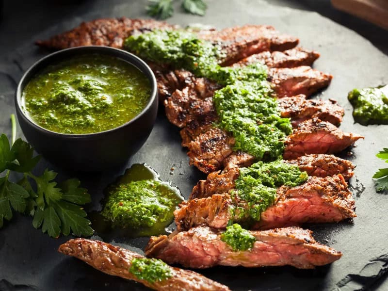 image 14522 - For a twist on steak night, it’s time to head way, way south of the border, all the way to Argentina. After marinating the skirt steak for 4 hours, sear it on the grill and serve it alongside the herbaceous and garlicky chimichurri sauce. Mouthwatering Skirt Steak with Chimichurri is a fresher take on traditional steak sauce and allows you to expand your cooking horizons a bit to include other cultures. For extra points, pair with an Argentinian malbec.
