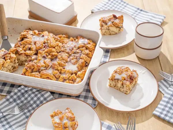 image 14615 - This Sinful Cinnamon Roll Bake really is just that devilishly delicious! Slice after slice of tender, cinnamon-swirled pieces are baked in a creamy custard and topped with brown sugar-coated pecans! Then comes the tangy, creamy frosting on top, because cinnamon rolls need frosting! It's a tried-and-true partnership much like peanut butter and jelly, or slices of Sinful Cinnamon Roll Bake and big smiles!