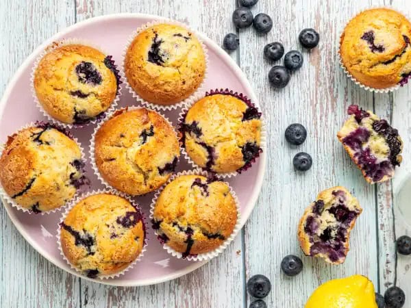 image 1469 - One of the greatest hosting hacks of all time is making something boxed taste homemade. These Better Blueberry Boxed Muffins are the perfect proof of how to make something taste like you've spent hours in the kitchen... when really, you just threw a few things together. Those are the kind of recipes we live for! Every single one of your guests will believe that these amazingly moist, crumbly muffins, filled with big, bursting blueberries and topped with the most satisfyingly sugary crunch, were made from scratch. And hey, they don't need to know otherwise! Bake to impress, but make sure you work smarter not harder, with some Better Blueberry Boxed Muffins! They're so unbelievably delicious!