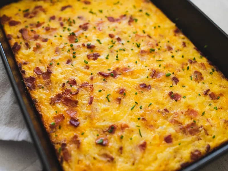 image 15031 - Start your day off the right way with this hearty and delicious Amish Breakfast Bake! This casserole is loaded with all of your breakfast favorites, including fluffy eggs, crispy potatoes, succulent bacon, and a trio of melty cheeses that will make your tastebuds sing. With cheddar cheese for richness, Swiss cheese for nuttiness, and a touch of cottage cheese for creaminess, this breakfast bake is the ultimate in cheesy, comforting goodness. Whether you're feeding a crowd or just looking for a hearty breakfast to enjoy all week long, this Amish Breakfast Bake is sure to satisfy!