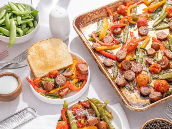 image 15063 - We all know that getting a great holiday dinner on the table can be a major stressor in a season marred by too many stresses already! So why put in all the work? Easy Christmas Sheet-Pan Supper makes sure your special gathering has a dish that's hearty, wholesome, and worry-free! Place the succulent sausage, the bright peppers and tomatoes, the sweet sugar snap peas, and the savory green onions on a sheet tray, give a little seasoning, and roast! Bam! The holidays are marked by platefuls of culinary cheer, ready to be piled on toast, thanks to this Easy Christmas Sheet-Pan Supper!