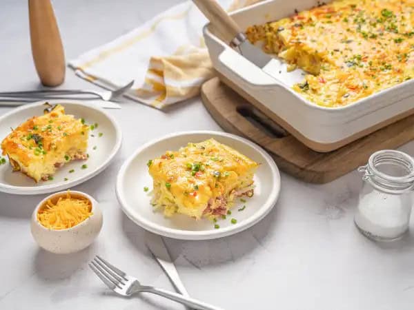 image 16639 - Trust us, you don't want to hit snooze on this dish! Snooze Casserole features salty ham and tender-yet-crunchy hashbrowns nestled in a bed of fluffy, creamy eggs, as well as some bright sautéed vegetables. What a wonderful way to start the day! Plus, because it is ready in under an hour, you can sleep in all you want before getting started on this Snooze Casserole. Your day is already starting off on the right foot!