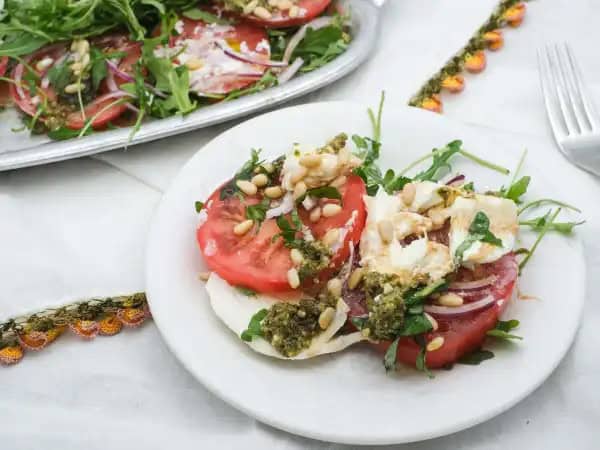image 16810 - Part of the fun of going on vacation is getting to experience new foods and flavors. Well, pack your bags (grocery bags that is) and try this fresh, vacation-like Tomato Burrata Salad right in your own backyard (or dining room). Almost like taking a furlough from the kitchen, this easy, made-in-minutes, vacation-on-a-plate salad will make it look like you pulled out all the stops. Picture it; fresh, crispy arugula, juicy, ripe tomatoes, flavor-packed red onions, and bougie, creamy burrata topped with some of the best balsamic glaze you can imagine. This picturesque Tomato Burrata Salad will definitely take you on a flavorful trip. So, take it easy, relax, and enjoy this salad sabbatical with the ones you love. A mind-vacay is a wonderful place to go! It's always in season... enjoy your trip!