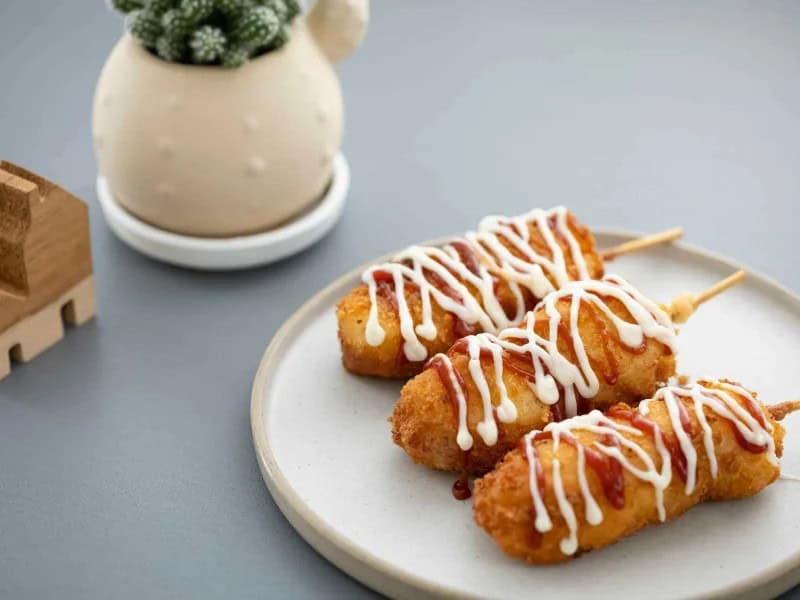image 16895 - Crispy Korean Corn Dogs are a unique twist on corn dogs that will blow your mind! Filled with meaty hot dogs and coated in a fluffy and fried breading, Crispy Korean Corn Dogs perfectly balance savory and sweet, They can even be dusted in sugar for extra sweetness! In just 40 minutes, you’ll be able to indulge in this yummy street food!