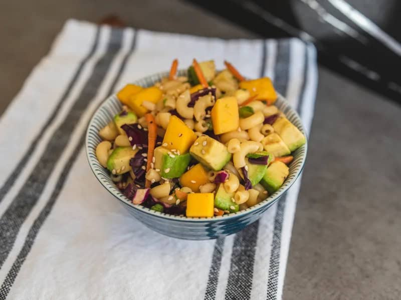 image 18370 - There isn't a pasta salad out there that can match the refreshment or the brightness of Asian Pasta Salad. The dressing alone is a showstopper, a savory and sweet soy sauce mixture with notes of butter and nuttiness from the sesame. But what it covers goes well beyond what you'd expect to find in a pasta salad: sweet and juicy mangoes, creamy avocados, crunchy red cabbage, and sharp green onions. Elbow macaroni ties everything together into a flavor parcel you can't wait to unwrap. Asian Pasta Salad shows that a little fusion in your cooking can really up the fun!