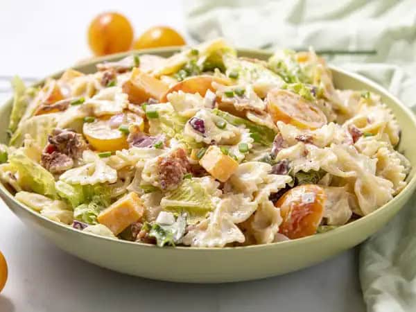 image 18721 - On the one hand, Loaded Pasta Salad is actually very simple; tender bow tie pasta, a creamy and herbaceous dressing, and some additions to make it all tasty. But on the other hand, it's an ensemble piece, a collection of succulent bacon, bright tomatoes, sharp cheese, and spicy red onion making each bite of pasta something truly special. No matter how you choose to look at it, Loaded Pasta Salad really does deliver a big load of flavor in a hurry!