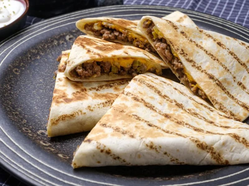 image 2022 - When Tuesday night is practice night, meeting night, or just a chaotic night, these Easy Beef Quesadillas have your Taco Tuesday substitute in the bag (or in a tortilla shell we should say). The chile-drenched ground beef all snuggled into golden-brown tortillas will slow you down just long enough for your tastebuds to savor all these delicious flavors. Let these flavor-packed quick grabs, known as Easy Beef Quesadillas, be your busy night dinner rescue. It saves you time, your family will be filled up, and no one will miss a beat! Everyone wins!