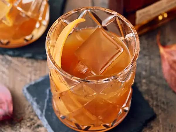 image 20843 - We know the old-fashioned is a fall drink, but we thought we'd elevate said fall flavors just a little bit more. Raise your rocks glass to this Fall Old-Fashioned, a smooth sipper that brings hints of vanilla, oak, maple syrup, and pumpkin! Yep, that's right. Like we said, this amber-colored classic gets a slight upgrade to really embrace those beloved autumn flavors. Garnished with a citrusy orange peel, this Fall Old-Fashioned is perfect for any leaf-falling occasion!