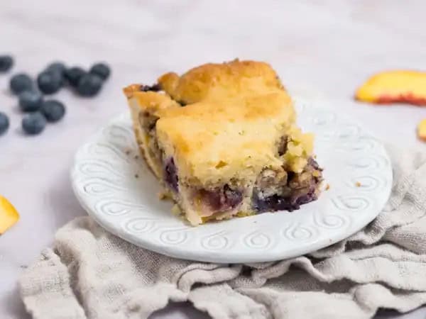 image 21164 - We've all heard of fruit-at-the-bottom yogurt, but what about Fruit-Bottom Cake? That opens up a whole new world of dessert possibilities! A tender, fluffy vanilla cake covers a layer of jammy, floral peaches, and bright, summery blueberries, so all that wonderful fruit flavor soaks into the cake! Plus, it's topped with a candied pecan crust with notes of warm cinnamon and smoky brown sugar! There's just so much to love about Fruit-Bottom Cake, you'll be amazed it can all fit on your fork!