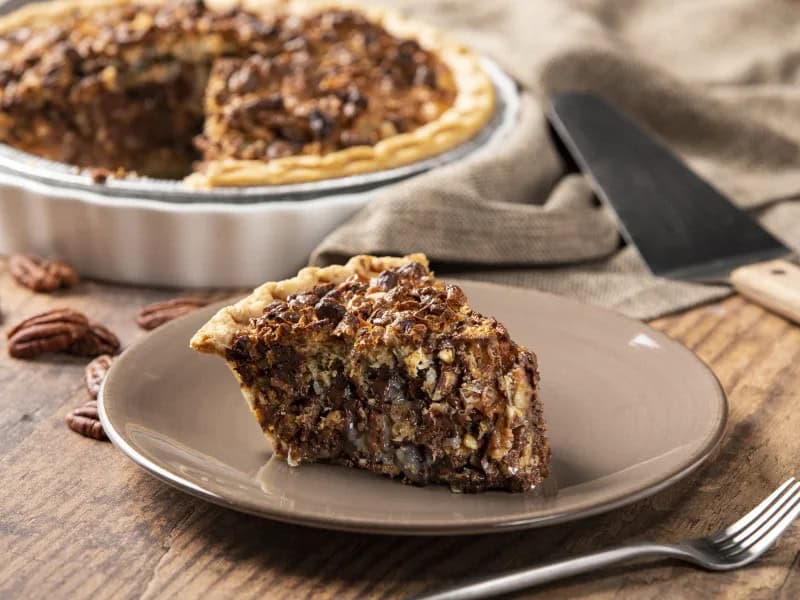 image 21830 - Endearingly named for its plethora of pantry ingredients that you don't use together, there's one thing we're certain of: there's absolutely nothing trashy about the Texas Trash Pie. In fact, the contrasting ingredients of this tasty treat are next-to-none with the sweet and salty flavors and the crunchy and creamy textures. Mmmmmm, we're drooling just thinking about the rich chocolate, the salty pretzels, the sweet graham crackers, the tropical coconut shreds, the divine caramel bits, and of course, the signature Texas pecans. Plus, you can whip up this crowd-pleasing pie in one hour's time. If this is truly trashy (it's not), then we must be raccoons (we're not).