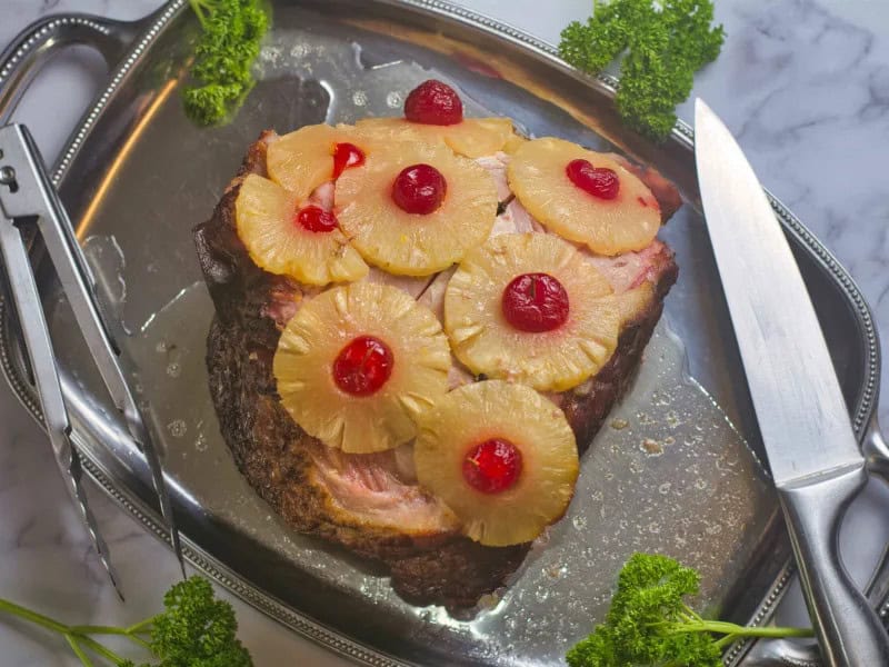 image 2546 - For all the jokes about pizza toppings, pineapple and ham are actually a classic combination when done correctly. It doesn't get more correct or more perfect than Pineapple Honey-Glazed Ham. Tender-cooked ham covered with a sweet, fruity, and slightly tart glaze, with juicy pineapple slices, this show-stopping main course is as beautiful to look at as it is to eat. Festive flavors make Pineapple Honey-Glazed Ham a holiday treat that will keep you glancing at the calendar for the next occasion (and excuse) to roast one up.