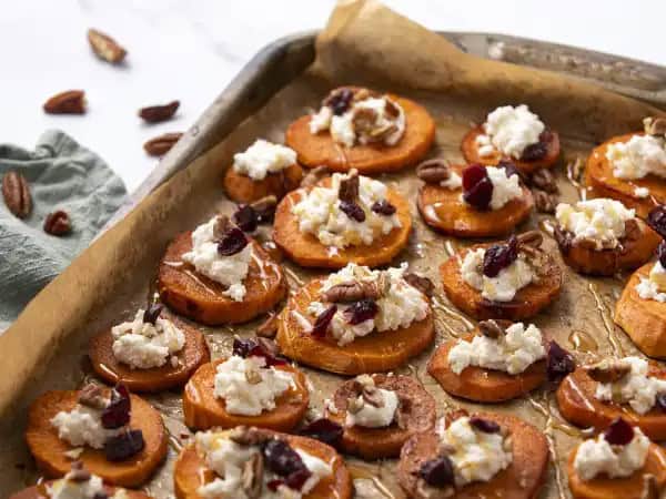 image 4702 - Sweet Potato Snacks really go all on in on the sweet aspect of these sunset-golden tubers! Each tender round is brushed with cinnamon-sugar and then topped with a tangy and floral goat cheese and honey whip! A sprinkling of candied pecans and sweetened cranberries brings the snackable vibes to new heights and adds dimension to the candy-like goodness on display! Sweet Potato Snacks are hearty treats with a dessert-like edge!