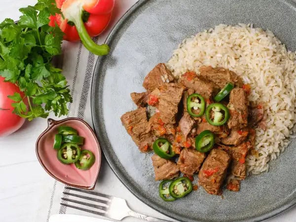 image 5705 - Salsa Beef is more about beef than salsa, but both play an integral part of this dish! The beef is slow-cooked in a vibrant salsa mixture, with soy sauce to enhance the umami flavor and brown sugar to add a dimension of sweetness and smokiness. Then the beef is served on nutty brown rice with spicy peppers, ensuring that the tender, beefy chunks form a complete and delicious meal! Salsa Beef will make you want to salsa!