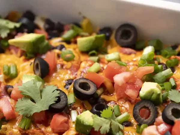 image 6257 - Poker Night Enchiladas are here to help feed you and a card table of your friends in the best way possible! Layers of tender tortillas, juicy chicken, and spicy red enchilada sauce are nestled between melty cheese and hearty black beans, then baked until bubbly! You'll definitely find yourself with a winning hand with Poker Night Enchiladas on a plate by your side! Your taste buds will certainly be going home with a winning feeling!