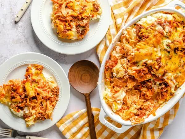 image 6871 - We aren't sure exactly how this tasty combination came to be, but we are sure glad it did! Granny's Beef Bake is the all-time most requested casserole at each and every gathering, and in just a couple bites, you will understand why! Granny knows how to please with all the layers of perfectly seasoned, tomato-sauced ground beef and the tangy sour cream-cream cheese combo, all snuggled in with wavy egg noodles and then topped with that melted sharp cheddar cheese. You know, we don't know if this was an accidental or planned cooking experiment for her, but we do know that Granny's Beef Bake sure passes the taste test every single time. It is Granny-created and everyone-approved!