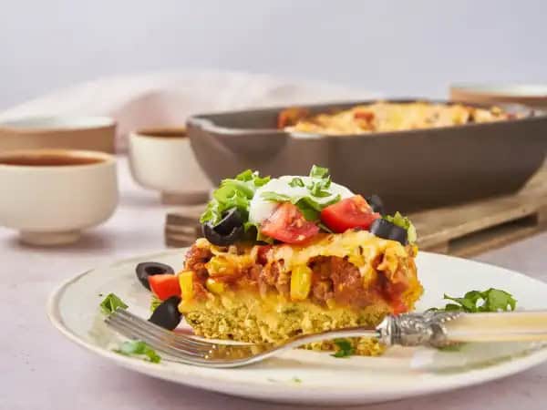 image 7067 - This is how Abuela liked to do her casserole, especially when it was Taco Tuesday. A biscuit-like bottom layer with fragrant cilantro holds up a classic zesty, spicy, savory taco meat filling! The salsa and corn are mixed right in for extra vibrance and flavor! Served with your favorite taco toppings, Abuela's Taco Casserole becomes the greatest taco experience you could never have imagined before... but it's the one you'll be dreaming of henceforth!