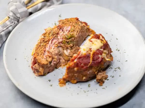 image 7096 - This Italian Meatloaf comes stacked! It starts off stacked with three kinds of meat, hearty beef, spicy sausage, and salty deli ham. Then, it's stacked with melty cheese, fresh herbs, and rich pizza sauce. Really, it's stacked with all sorts of heartiness and satisfaction, so this Italian Meatloaf is the mound of yum you've been craving!