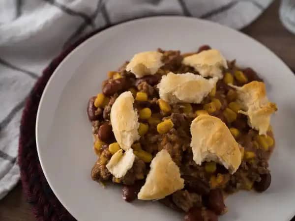 image 7922 - Yee-haw! If this isn't the most delicious casserole on either side of the Mississippi, well then, we'll be a prairie dog's uncle! The Wild West Casserole is loaded with hearty beef, creamy beans, and sweet summery corn. Then, you find some sharp cheese mixed in for extra country flavor. To finish, the Wild West Casserole rides up to you on a silver steed (aka your spoon) and delivers the blessing of a golden, buttery biscuit. We reckon there isn't a tastier dish in these here states, but you can be the very happy judge of that!