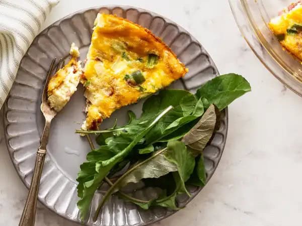 image 8309 - Is Ham N' Cheese Pie a pie or a quiche? Hard to say for sure, but it's delicious no matter its label! Ham N' Cheese Pie is loaded with savory ham, creamy Swiss cheese, sharp cheddar, and plenty of bacon, all within a fluffy, seasoned bed of eggs! You can just melt away into the melty goodness of this Ham N' Cheese Pie; it's not just a breakfast of champions, it's the champion of breakfast!
