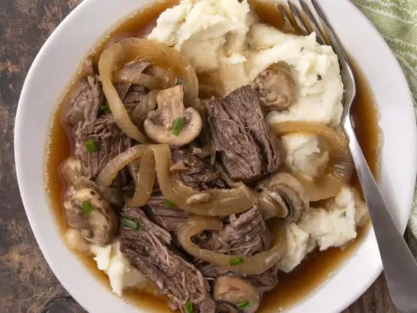 image 8918 - This beef really wants to kick back just like you, and thankfully it's so easy, you don't have to break your weekend flow to make it! Boozy Roast Beef slow-cooks the hearty, savory, extra-tender roast in not just beef stock, but beer as well, imparting the malty flavor into the meat and getting dinner in a festive mood! When served atop fluffy mashed potatoes to soak up all the extra flavor, Boozy Roast Beef becomes a dinner you look forward to all day, all week, and all the time!