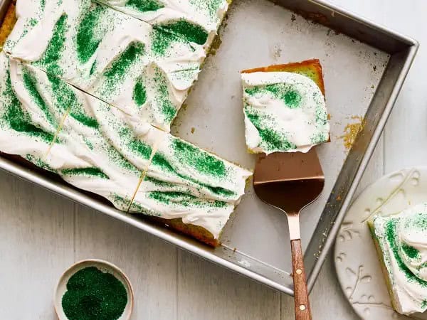 image 893 - When you're all your decked out head-to-toe in your green gear on St. Patrick's Day, Can't-Pinch-Me Poke Cake will be the extra nudge of fun you'll just love! This sweet, very moist treat comes ladened with hints of vanilla and marble-y swirls of green, thanks to some citrusy lime gelatin. Um, yum! Topped with creamy vanilla frosting and a sprinkle of green sanding sugar for extra luck, nothing can ever pester you when Can't-Pinch-Me Poke Cake is being served!