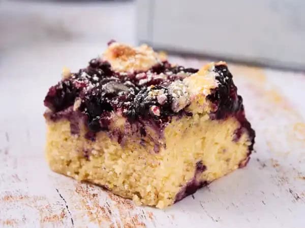image 9395 - The Blueberry Buttermilk Breakfast Bake, or The BBBB, is a dessert you can and should eat for breakfast! Is there a better way to start the day? Little bursts of tart, bright blueberries swirl in a tender cake with the wonderful tang of buttermilk running throughout. It's sweet and moist and a little sprinkle of sugar on top just adds to the wonder of having slice after slice! The BBBB is a beautiful brunch or breakfast bounty!