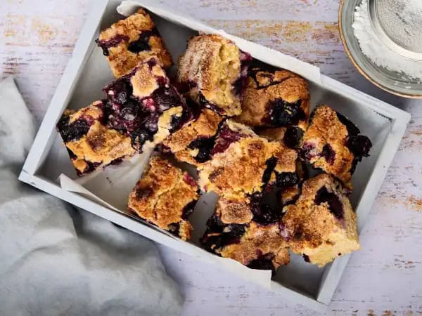 image 9407 - The Blueberry Buttermilk Breakfast Bake, or The BBBB, is a dessert you can and should eat for breakfast! Is there a better way to start the day? Little bursts of tart, bright blueberries swirl in a tender cake with the wonderful tang of buttermilk running throughout. It's sweet and moist and a little sprinkle of sugar on top just adds to the wonder of having slice after slice! The BBBB is a beautiful brunch or breakfast bounty!