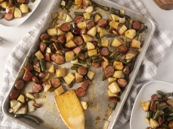 image 9613 - Easy — check! Economical — check! Delicious — check! Sheet-Pan Garbage checks all the boxes for an amazingly delightful meal! When all laid out, petite but mighty red potatoes, spicy kielbasa, tender green beans, and flavorful onion all sprinkled with steak seasoning become that full-on, no-time-to-waste, great taste! Grab a clean sheet pan and make Sheet-Pan Garbage. It's a quick, weekly, pick-me-up meal your entire family will love! It's "pan-tastic!"