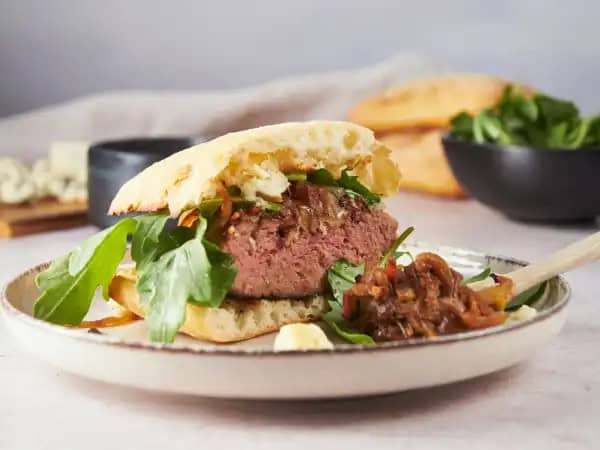 image 9807 - Taking a day off, a much-deserved day off at that, deserves something special to savor. Oh yes, now's not the time for fast food. Now's the time for these Out-of-Office Burgers. With just a little extra time, you can enjoy juicy grilled burgers on buttery baguettes, topped with smoky Gruyère and tangy blue cheese! But the real secret to Out-of-Office Burgers is the jammy, sweet, and succulent onion-bacon compote; there's no need for condiments when you have that piled high on your burger! Maybe today is a good day to take a little time for yourself by the grill!