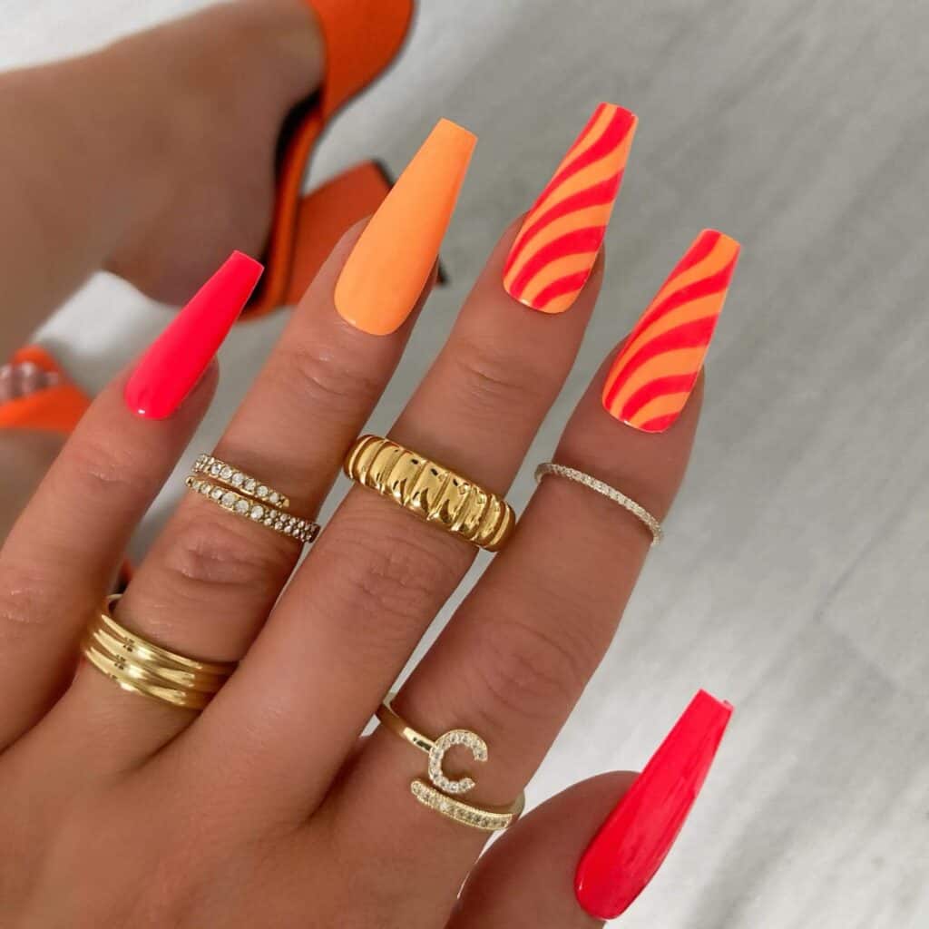 Chic summer nails featuring vibrant orange hues, from neon to burnt with glitter accents, perfect for adding a seasonal touch.