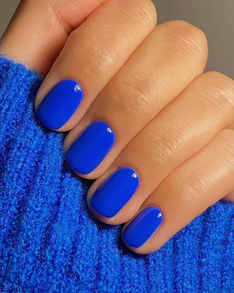 Varied blue nail designs showcasing light blue nails, royal blue acrylic nails, and blue French tips in different hand poses.