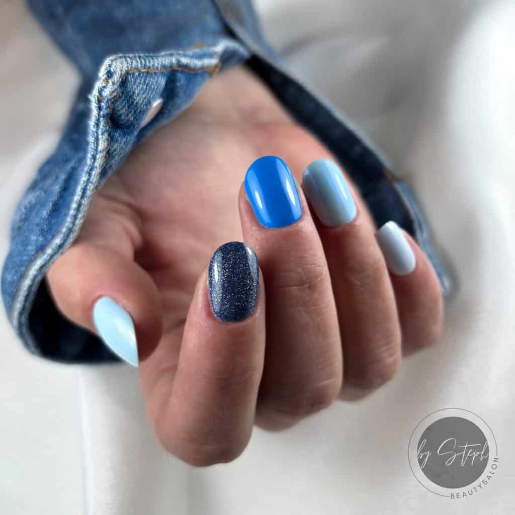 Varied blue nail designs showcasing light blue nails, royal blue acrylic nails, and blue French tips in different hand poses.