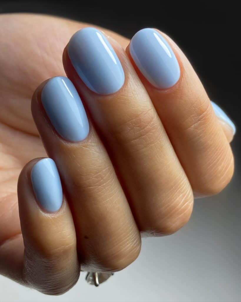 Varied blue nail designs showcasing light blue nails, royal blue acrylic nails, and blue French tips in different hand poses.