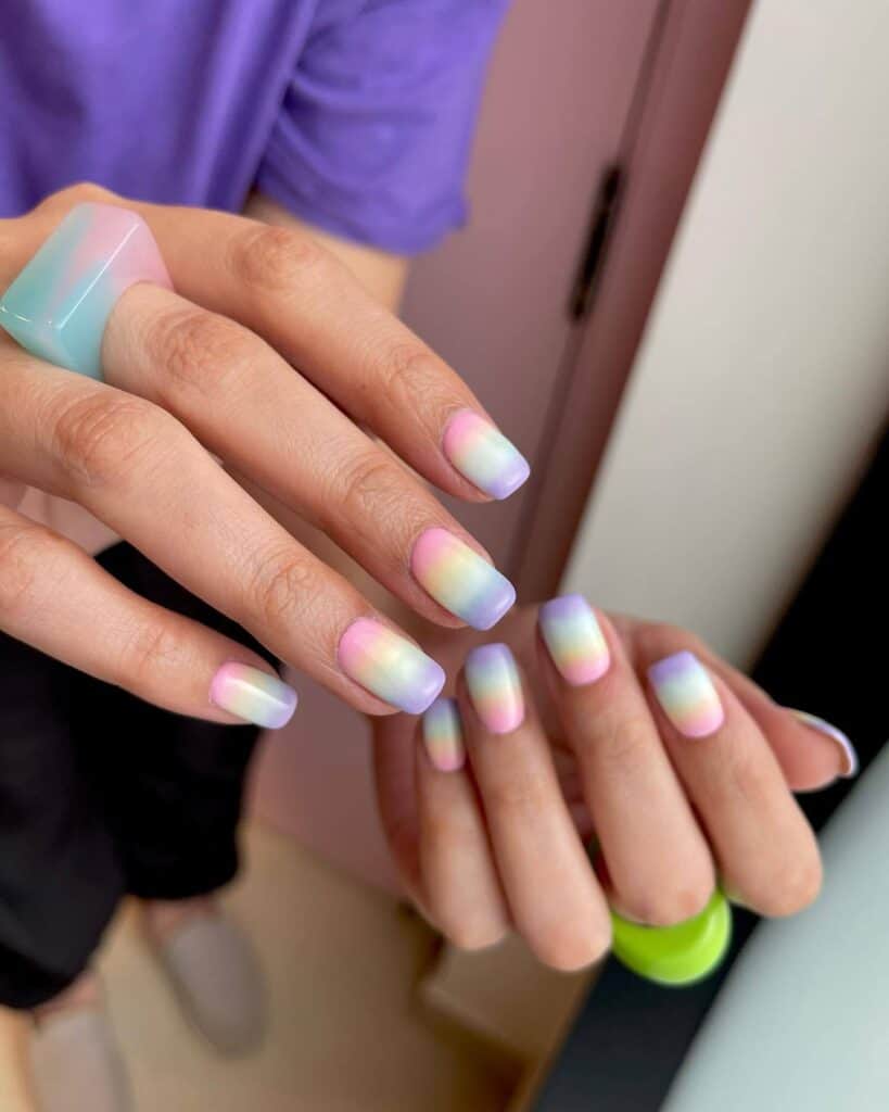 Detailed shot of festive nails showcasing candy cane stripes, lollipop swirls, and candy corn patterns in bright, vibrant hues.