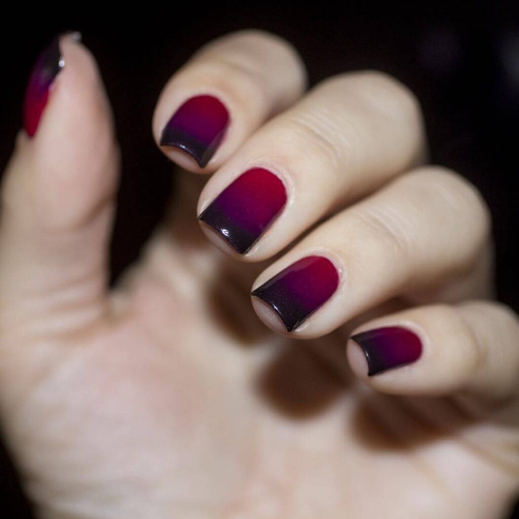 A selection of gradient nail styles such as autumn hues, black to red transitions, and blue glitter fades.