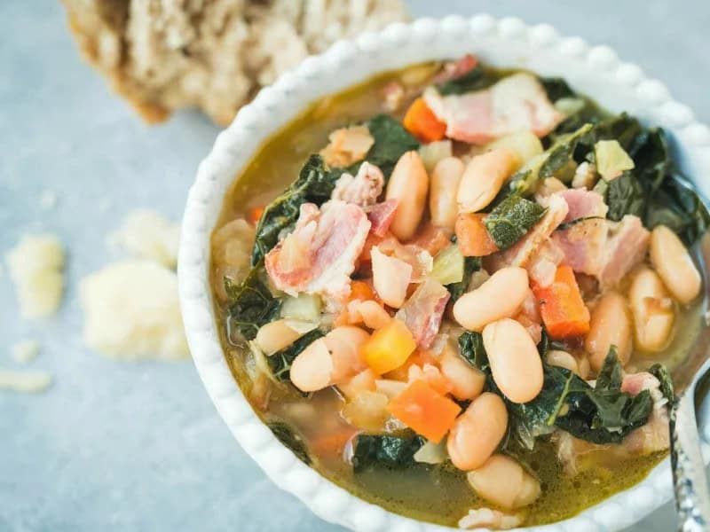 image 1249 - The famous Tuscan soup, Ribollita, may have begun its life as a peasant dish, but it is certainly rich with flavors and textures. Filled with fresh garden vegetables and savory, hearty beans, Ribollita is hearty and satisfying, perfect for when the weather cools down. With bites of fatty pancetta, sips of flavorful, savory, and cheesy broth, and drizzles of tangy, bright oil, you'll be mopping this soup up with every bit of bread you can find! Get ready to drink this dish straight from the bowl!