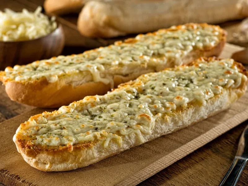 image 247 185 - Skip the frozen garlic bread! Homemade Cheesy Garlic Bread has more of that irresistible buttery, savory, and cheesy flavor—the perfect addition to any meal. Best of all, it takes only 20 minutes to make and serves enough garlicky goodness for the whole table, or enough to have as leftovers the next day. Cheesy Garlic Bread is so crispy and delicious, you may be tempted not to leave any leftovers behind!