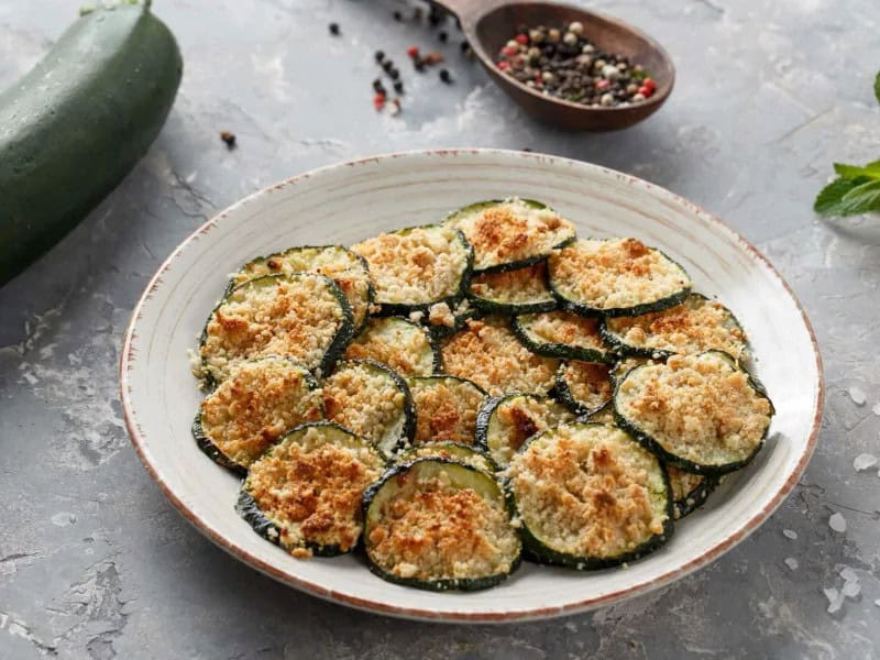 image 247 208 - This recipe for Roasted Parmesan Zucchini Bites is savory, cheesy, and versatile enough to work as a side dish, appetizer, or even a snack! Roasted zucchini is perfectly seasoned with olive oil, salt, pepper, and sharp parmesan cheese. These tasty bites are delicious as-is, or they can be paired with tomato sauce for a fresh spin. Roasted Parmesan Zucchini Bites are easy to make and fun to eat!