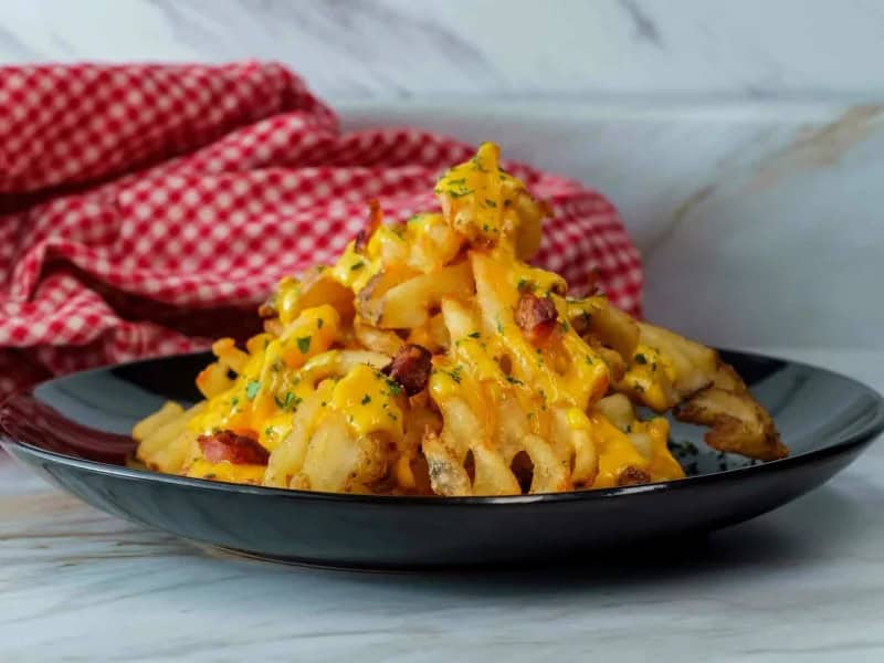image 247 286 - While the best fry cut is one of the great debates of our times, waffle fries certainly rank towards the top of the list. More surface area means more crunch and more satisfying fries overall. Loaded Waffle Fries take advantage of the wide shape to top them with melty sharp cheese, salty bacon bits, and tangy green onions. Seasoned with smoky, savory spices, Loaded Waffle Fries are a pull-apart, lick-your-fingers, go-back-for-more potatoes layered with deliciousness. Taking 30 minutes or less to make, this is a dish you'll be going back to all the time!