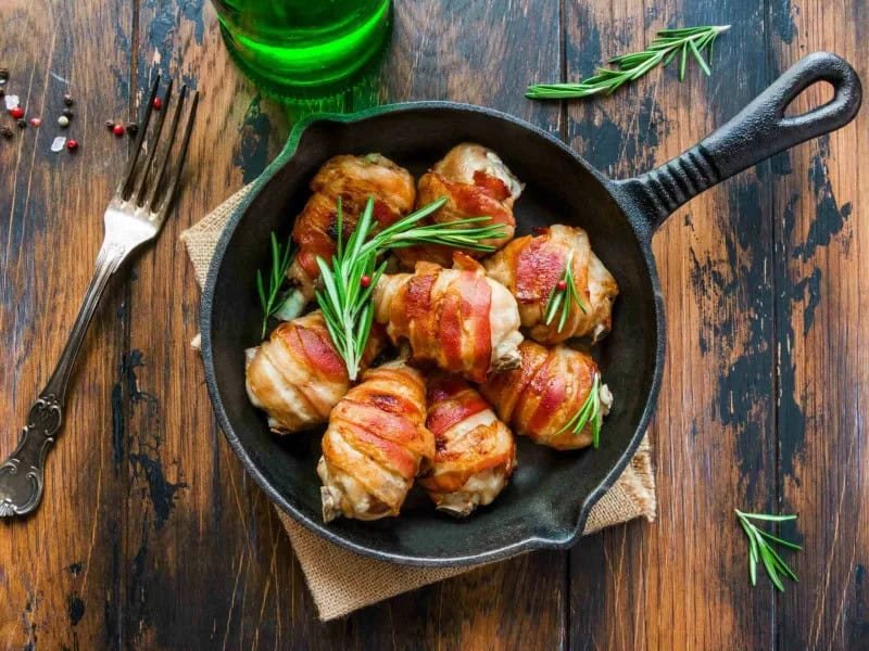 image 247 296 - Chicken and bacon might as well be best friends, they go so well together! Bacon-Wrapped Drumsticks brings the pair together for the perfect combination of savory, fatty flavors. Tender chicken drumsticks are wrapped in crispy bacon and seasoned to perfection with salt, pepper, rosemary, and parsley. Bacon-Wrapped Drumsticks for a hearty dish yet indulgent dish you can eat one-handed!